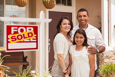 family standing in front of a newly purchased home